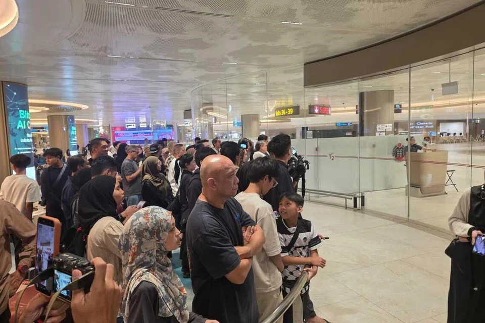 Orang ramai menanti ketibaan keluarga mereka yang tiba dengan penerbangan SAF14 di balai ketibaan Terminal 2, Lapangan Terbang Changi, pada 13 Mac.