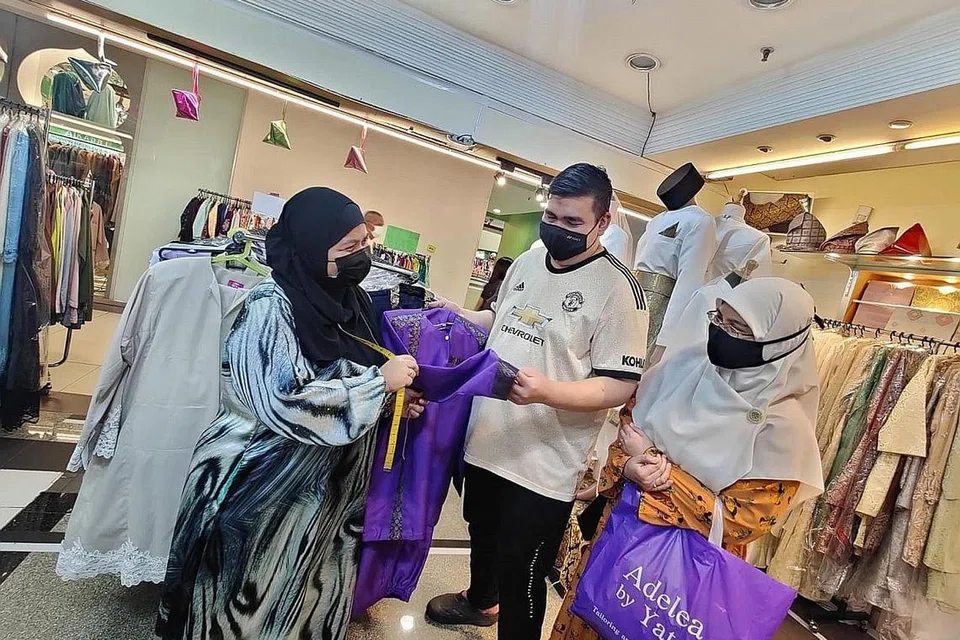 AWAL-AWAL DAH TEMPAH BAJU RAYA: Cik Yate melayan pelanggannya, pasangan suami isteri Encik Haniffa dan Cik Zuhaila, yang telah membuat tempahan baju Raya. - Foto BH oleh NUR DIYANA TAHA