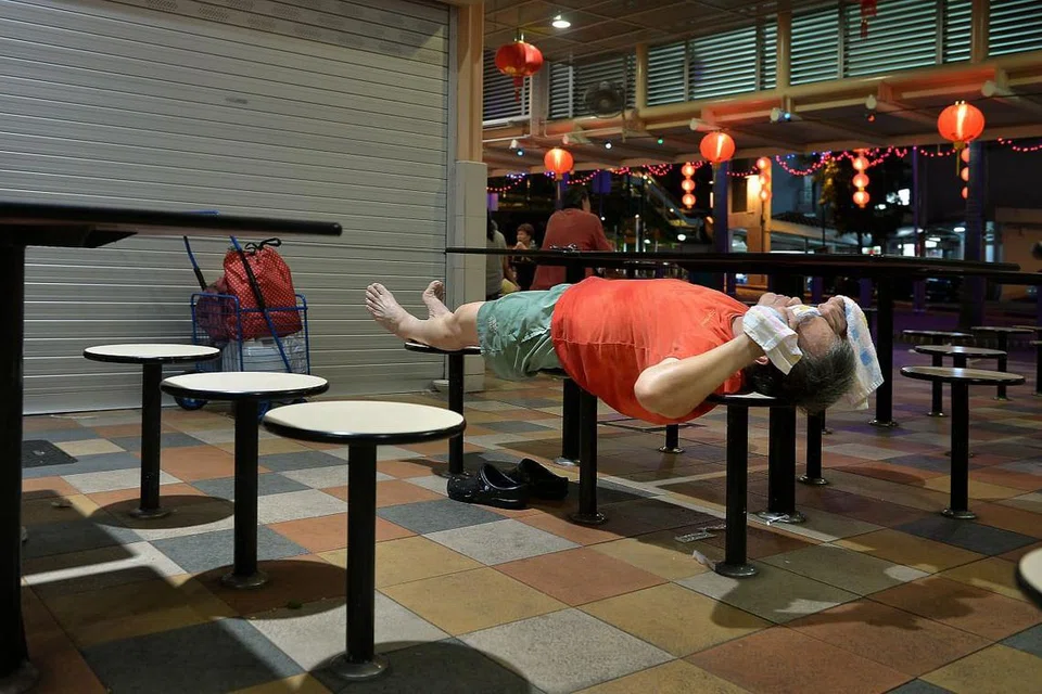 Seorang penjaja tidur selepas penat bekerja di gerainya di sebuah pusat penjaja. 