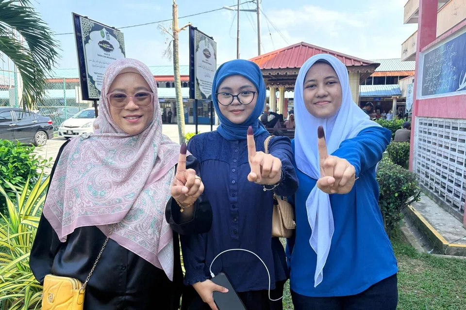 Pengundi muda, Cik Ayu Sofia Abas, 19 tahun (tengah), dan Nur Lailatul Aqma, 19 tahun (kanan), datang bersama ibu saudara mereka, Cik Rohaida Abu Samah, 41 tahun, ke pusat mengundi di Sekolah Menengah Kebangsaan Dato Klana Petra Maamor, di Ampangan, Seremban, Negeri Sembilan.