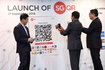 KOD QR UNIVERSAL: (Dari kiri) Anggota lembaga Penguasa Kewangan Singapura (MAS) Ong Ye Kung, pengarah urusan MAS Ravi Menon dan timbalan ketua eksekutif Penguasa Pembangunan Infokom Media (IMDA) Leong Keng Thai, melancarkan SGQR.