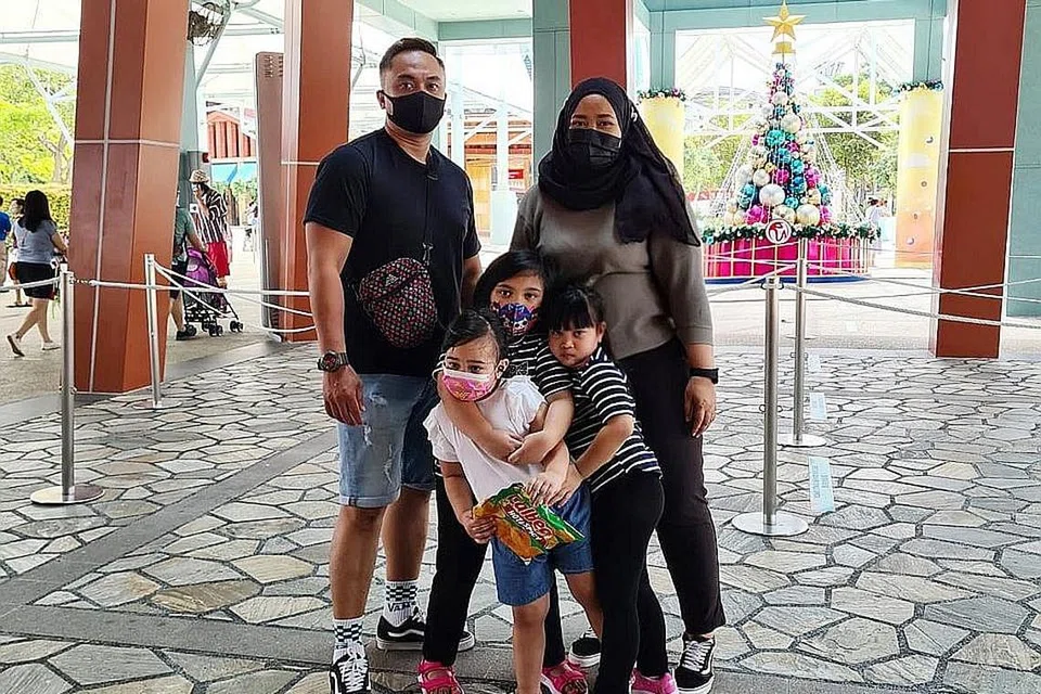 MEMBUAT RANCANGAN ALTERNATIF: Walaupun terpaksa membatalkan melancong ke Jepun tahun ini, Cik Mastura bersama suaminya Encik Taufik Jufri, dan anak-anaknya, (dari kiri) Ain Farha Taufik, Afrin Farisha Taufik dan Aufa Fariha Taufik telah memanfaatkan Baucar Teroka Semula Singapura untuk mengunjungi S.E.A Aquarium semalam. - Foto ihsan MASTURA DAWOOD