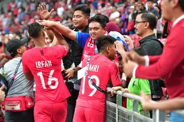HARGAI SOKONGAN PENYOKONG: Irfan Fandi dan Khairul Amri beramah mesra dengan penyokong yang hadir bagi menonton perlawanan antara Singapura dengan Indonesia di Stadium Negara pada 9 November 2018.