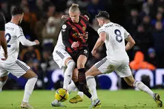 TIDAK DAPAT DIHALANGI: Haaland (jersi belang-belang) mengawal bola walau dihalang pemain Leeds. Beliau menjaringkan dua gol dalam kemenangan 3-1 Manchester City kelmarin. - Foto AFP