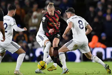 TIDAK DAPAT DIHALANGI: Haaland (jersi belang-belang) mengawal bola walau dihalang pemain Leeds. Beliau menjaringkan dua gol dalam kemenangan 3-1 Manchester City kelmarin. - Foto AFP