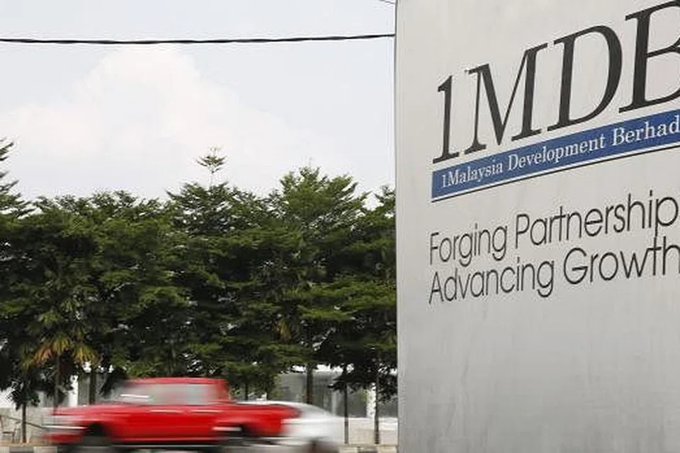Trafik melalui papan iklan 1Malaysia Development Berhad (1MDB) bagi pembangunan Bursa Tun Razak di Kuala Lumpur dalam gambar fail pada 6 Julai ini. Gambar REUTERS 