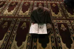 Seorang lelak sedang beribadah dalam masjid.