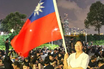 TUNJUK BANTAHAN: Penduduk Hongkong, Cik Yung Xiu Kwan, 67 tahun, bergambar dengan memegang bendera Taiwan semasa membantah terhadap undang-undang ekstradisi yang dicadangkan yang membolehkan orang di Hongkong dihantar ke tanah besar China. - Foto REUTERS