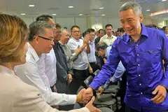 BERINTERAKSI: PM Lee bersalaman dengan pemimpin gerakan buruh semasa sesi dialog tertutup bersama mereka semalam. - Foto KHALID BABA