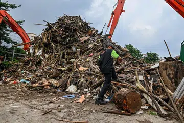 BANYAK SAMPAH: Seorang pekerja kelihatan sedang membersihkan sampah dan serpihan pokok di tepi sebuah sungai di Jakarta, selepas berlakunya banjir besar di ibu kota itu pada awal tahun baru lalu. - Foto AFP