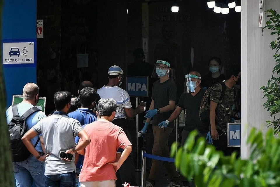 UJIAN SWAB MANDATORI PERCUMA: Orang ramai beratur di Pusat Pemeriksaan Daerah yang terletak di bekas Sekolah Rendah Da Qiao di Ang Mo Kio bagi menjalani ujian swab. - Foto BH oleh KUA CHEE SIONG