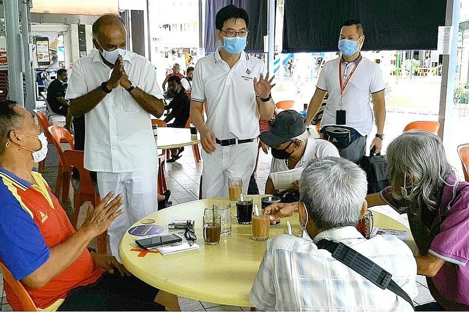 TEMUI PENDUDUK: Encik Shanmugam (kiri) dan seorang calon baru PAP di GRC Nee Soon, Encik Derrick Goh (tengah), sedang berbual bersama beberapa penduduk semasa mereka mengunjungi Pasar dan Pusat Makanan berdekatan Blok 414 Yishun Ring Road pagi semalam. - Foto BH oleh MOHD NOOR A. RAHMAN