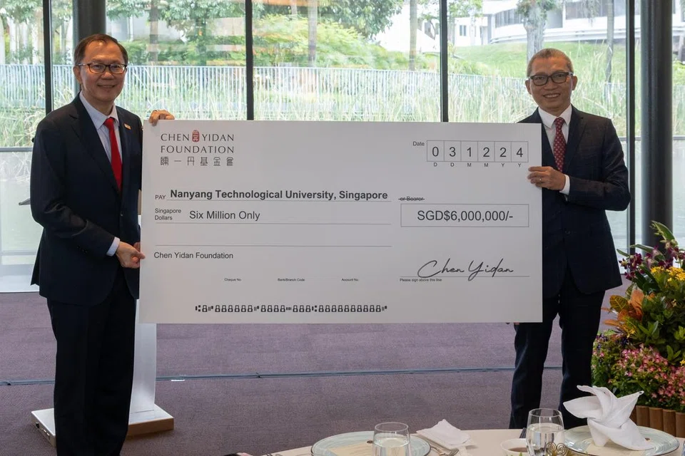 Presiden Universiti Teknologi Nanyang (NTU), Profesor Ho Teck Hua (kiri), dan pengasas yang juga pengarah Yayasan Chen Yidan, Dr Charles Chen Yidan, semasa majlis penyampaian cek di kampus NTU pada 3 Disember. 