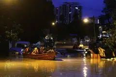 BANJIR KILAT: Pegawai penyelamat membantu beberapa penduduk yang terperangkap untuk keluar dari rumah mereka di Jalan P. Ramlee di Georgetown, Pulau Pinang.