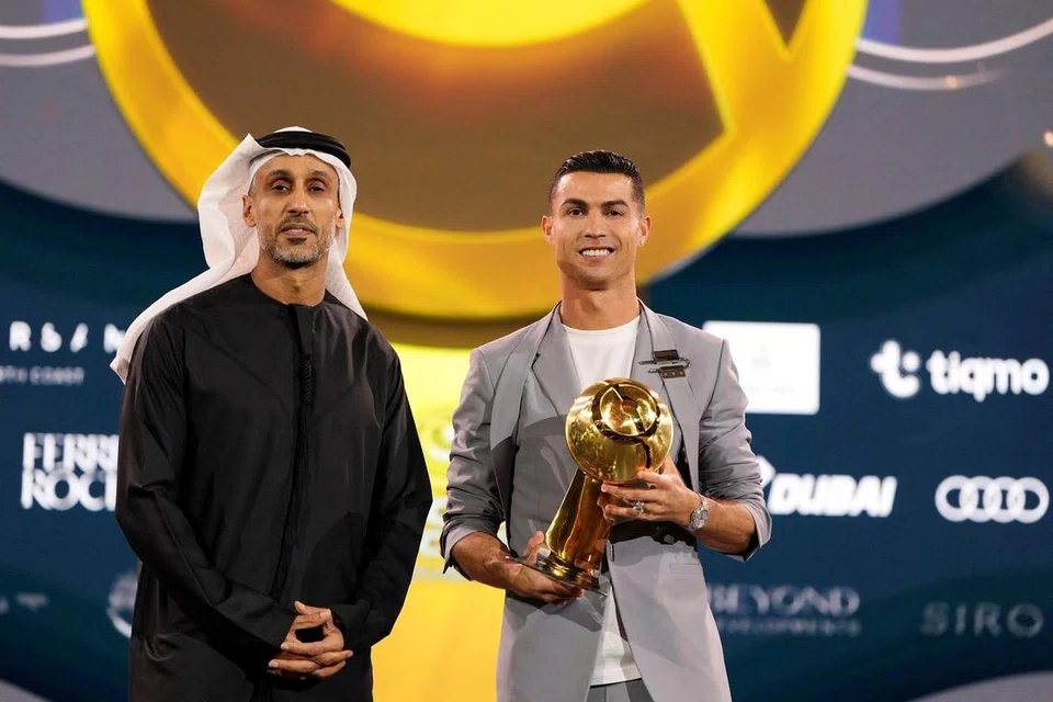 Cristiano Ronaldo (kanan) menerima piala Pemain Terbaik Timur Tengah pada 27 Disember 2024 semasa penyampaian acara, ‘Globe Soccer Awards’ yang diadakan di Dubai pada 2024.