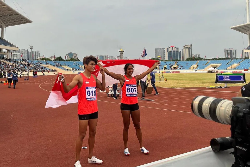 Marc (kiri) dan Shanti selepas kemenangan acara 100 meter larian pecut mereka di Stadium Nasional My Dinh pada petang Rabu. - Foto ZULAIQAH ABDUL RAHIM 