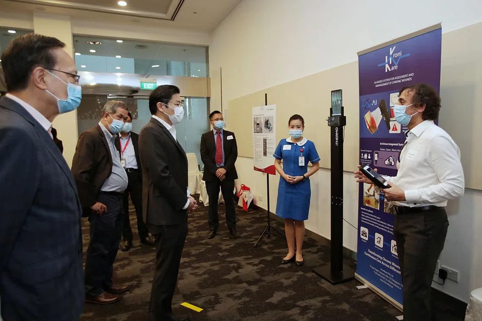 INTERAKSI BERSAMA: Encik Lawrence Wong (tengah) bersama (dari kiri) CEO KWSH, Dr Ow Chee Chung; Pengerusi Lembaga Pengarah KWSH, Encik Patrick Lee; dan Profesor Tan Thiam Soon beramah-tamah bersama CEO KroniKare, Encik Ali Y. Aladdin (kanan), dan pengurus jururawat Cik Serene Tan semasa lawatan ke SIT semalam. - Foto BH oleh GIN TAY