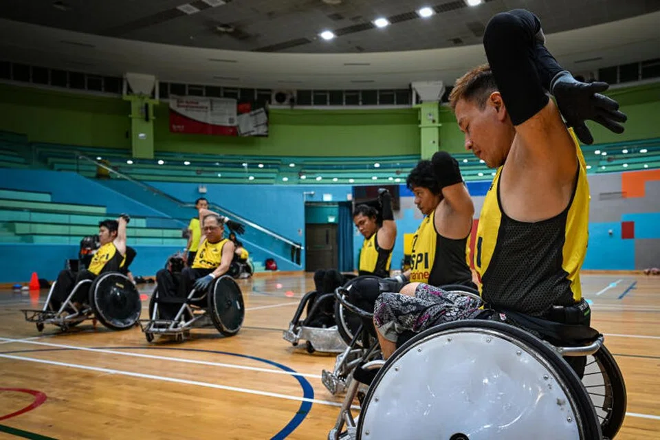 PANASKAN BADAN: Pemain ragbi kerusi roda memanaskan badan mereka sebelum memulakan latihan di Pusat Sukan Toa Payoh. 