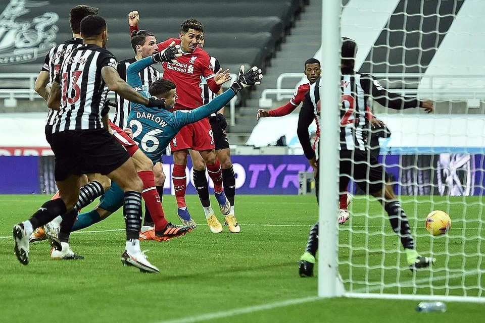 PERCUBAAN TERSASAR: Tandukan Roberto Firmino (jersi merah) tersasar sewaktu mengasak benteng pertahanan Newcastle. - Foto AFP 