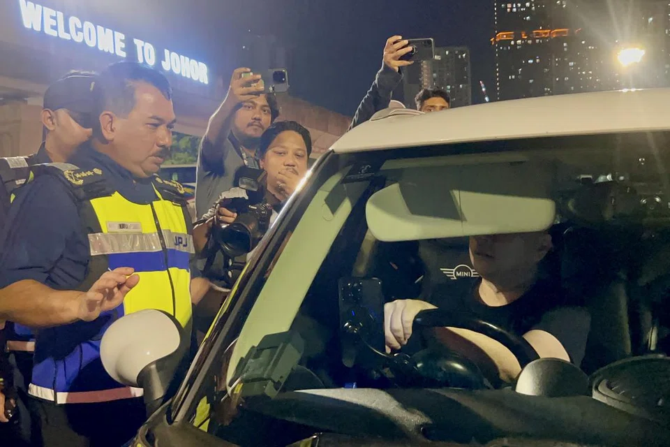 Pengarah Kanan Penguatkuasaan Undang-Undang Jabatan Pengangkutan Jalan (JPJ) Malaysia, Encik Muhammad Kifli Ma Hassan (kiri), memberikan penjelasan kepada seorang pemandu warga Singapura pada Ops Penguatkuasaan VEP di pintu keluar Kompleks Bangunan Sultan Iskandar (BSI), Johor Bahru.