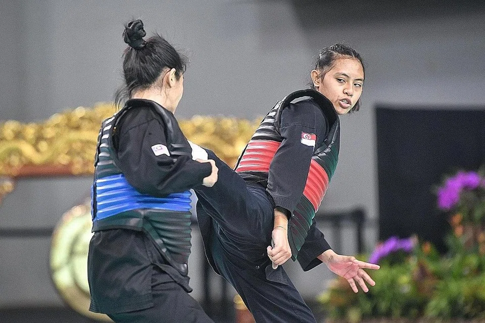 TUNJUK TARING: Nadhrah Sahrin (kanan) mengalahkan lawan dari Malaysia, Nor Farah Mazlan dalam final acara tanding puteri A senior (45-50 kilogram) di Kejohanan Pencak Silat Asia Tenggara 2022 di Dewan Satu OCBC Arena kelmarin. - Foto-foto BH oleh ARIFFIN JAMAR