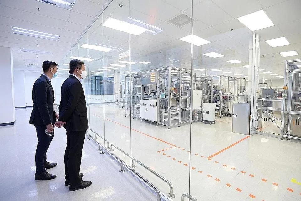 PERKEMBANG SEKTOR PERKILANGAN: Encik Chan Chun Sing bersama timbalan presiden dan pengurus besar Illumina Singapore, Encik Derric Lee, melawat prasarana syarikat tersebut semalam. Encik Chan menekankan Singapura ingin menarik syarikat seperti Illumina untuk merancakkan lagi bidang perkilangan. - KEMENTERIAN PERDAGANGAN DAN PERUSAHAAN