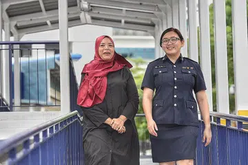 RELAWAN: Cik Nurul Shifa (kiri), relawan di bawah skim sokongan Skim sokongan itu dipanggil Skim Dewasa Sesuai bagi Suspek Muda (AAYS). Bersama dalam gambar adalah pegawai penyiasat SSG Neo Qiao Yi. - Foto BH oleh DESMOND WEE