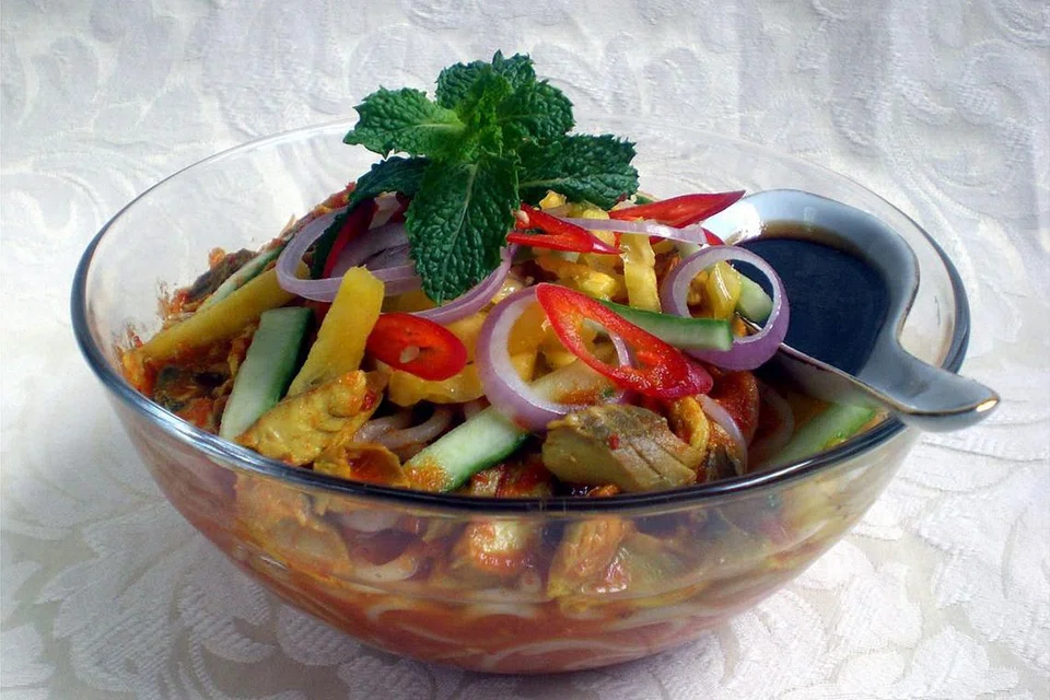 LAKSA ASAM, LAKSA LEMAK: Sesuai dengan namanya, laksa asam atau kadangkala dipanggil laksa Pulau Pinang (atas), rasa masam daripada asam gelugur yang digunakan. Selain dikisar, ikan yang menjadi bahan utamanya juga dicarik menjadi kepingan. Ia dihidangkan bersama hirisan timun, nanas, bawang besar, cili merah dan petis. Laksa lemak pula dimasak menggunakan santan, ikan yang dikisar, bebola ikan dan tauhu kering serta daun kesum bagi membangkitkan aroma kuahnya. - Foto JAMILAH M. HASSAN, RAVE PHOTOGRAPHY