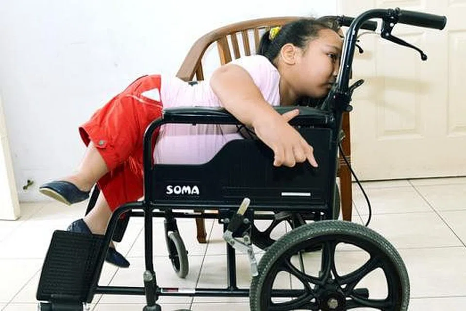 BOLEH PANJAT: Meskipun terkial-kial Nuralysya Abdul Hamid enggan dibantu dan mahu memanjat ke atas kerusi rodanya sendiri. 