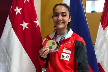 MEMBANGGAKAN: Amita Berthier dengan pingat emas yang dimenangi di Piala Dunia Junior di Guatemala Ahad lalu. - Foto PERSATUAN LAWAN PEDANG SINGAPURA