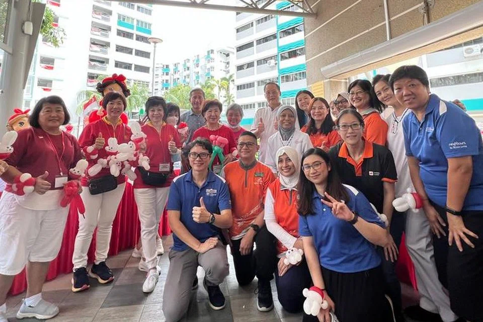 DEKATI PENDUDUK: Menteri Kedua Perdagangan dan Perusahaan, Dr Tan See Leng (di belakang, kanan, berbaju putih) dan Menteri Ehwal Luar, Dr Vivian Balakrishnan (di belakang, kiri, berbaju biru) bergambar bersama penduduk Marine Parade di Karnival Hari Kebangsaan Marine Parade pada Ahad.