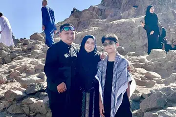 Cik Nazlin Hilal mengerjakan umrah ‘DIY’ bersama suaminya, Encik Shahrin Yem (kiri), dan anak bongsu mereka, Danish. Mereka bergambar di gunung tertinggi dan terbesar di Madinah, Jabal Uhud. 