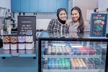 PASTRI LEBIH SIHAT: Cik Putri Nur Shafiqah Azman (kiri) bersama kakaknya, Cik Putri Zulaikha Azman (kanan) membantu mengandalikan gerai Simply DLights