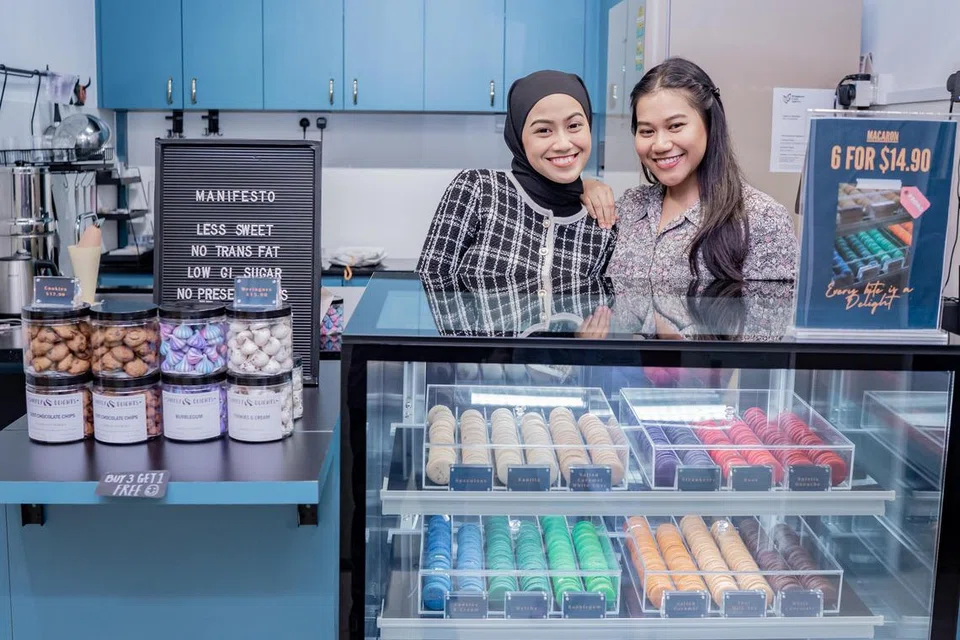 PASTRI LEBIH SIHAT: Cik Putri Nur Shafiqah Azman (kiri) bersama kakaknya, Cik Putri Zulaikha Azman (kanan) membantu mengandalikan gerai Simply DLights