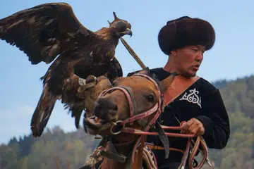 MEMBURU DENGAN HELANG: Salah satu sukan tradisional yang dipertandingkan memberi anda bayangan budaya memburu helang yang diamalkan masyarakat berkelana yang berkuda dalam perjalanannya. - Foto LAMAN WORLD NOMAD GAMES