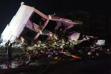 Penduduk memeriksa kawasan di sebuah bangunan yang runtuh akibat serangan udara Israel di perkampungan Kfar Jaouz, selatan Lebanon, pada 15 Oktober.