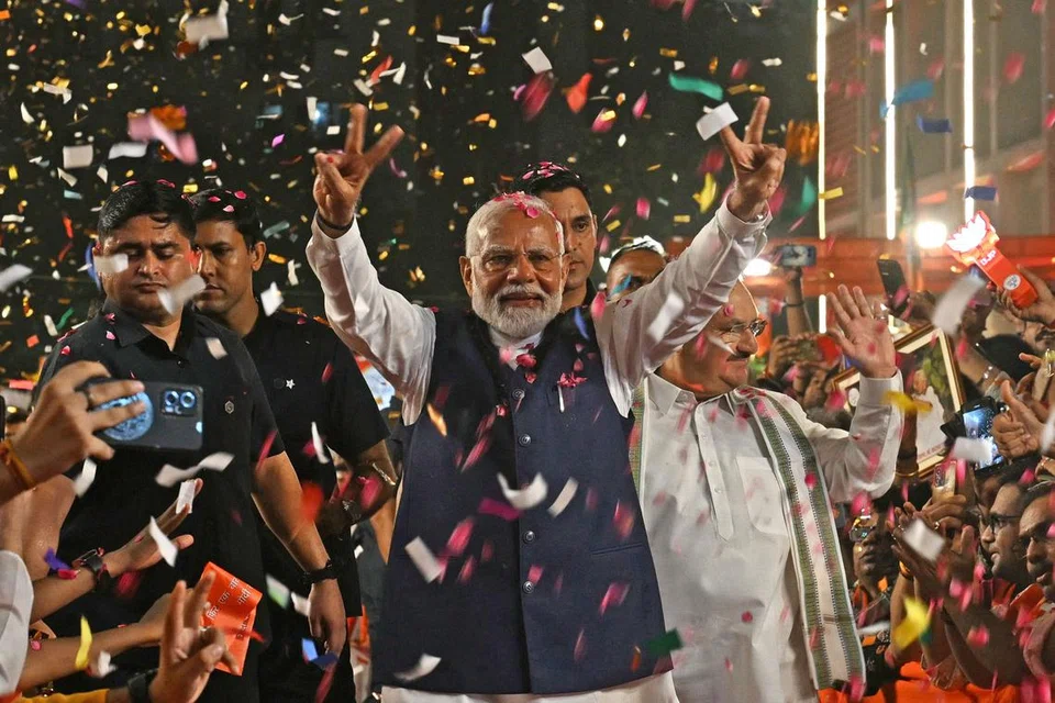 Perdana Menteri India, Encik Narendra Modi (tengah), meraih kemenangan dalam pilihan raya umum bersama penyokongnya di New Delhi. 