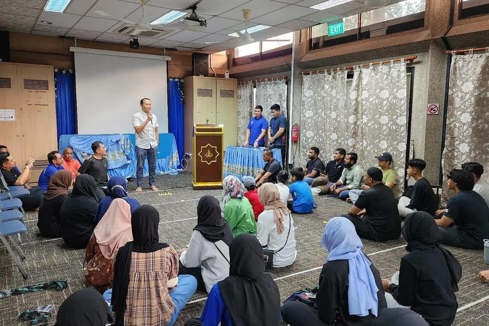 MENGGALAK SUKARELAWAN BELIA: Mayor CDC South East, Encik Mohd Fahmi Aliman, memberi ucapan kepada 70 belia MudaSG yang meluangkan masa untuk membantu membersihkan Masjid Darul Aman pada Sabtu pagi. - Foto MUDASG
