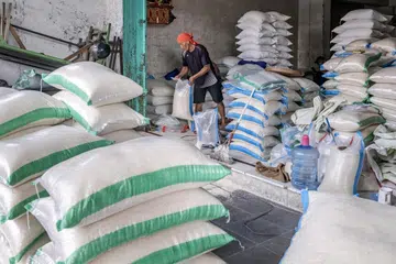 Penguasa Indonesia memberi jaminan, stok beras mencukupi bagi memenuhi keperluan terutama dalam bulan Ramadan dan menjelang Aidilfitri sedang seorang pekerja membungkus beras ke dalam guni di sebuah kedai di Denpasar, wilayah Bali, Indonesia, 26 Februari 2024. 