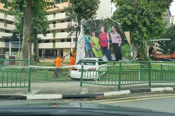 REMPUH PAGAR: Pagar jalan dirempuh kereta yang kemudian terhenti di rumput berhampiran gelanggang bola keranjang di Whampoa.