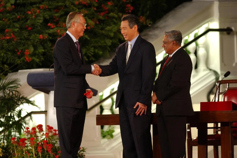 Encik Lee Hsien Loong (tengah) bersalaman dengan Encik Goh Chok Tong selepas mengangkat sumpah sebagai Perdana Menteri. Bersama mereka di majlis pada 12 Ogos 2004 itu ialah Presiden S. R. Nathan.