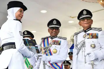 Pengarah Jabatan Siasatan Jenayah Komersial Bukit Aman, Datuk Seri Ramli Mohamed Yoosuf (dua, kanan) menyampaikan sijil bagi Anugerah Terbaik Keseluruhan Latihan kepada Sarjan Percubaan, Cik Siti Fairuz Abdullah (kiri) di Pusat Latihan Polis Kuala Lumpur, pada 7 Jun. 