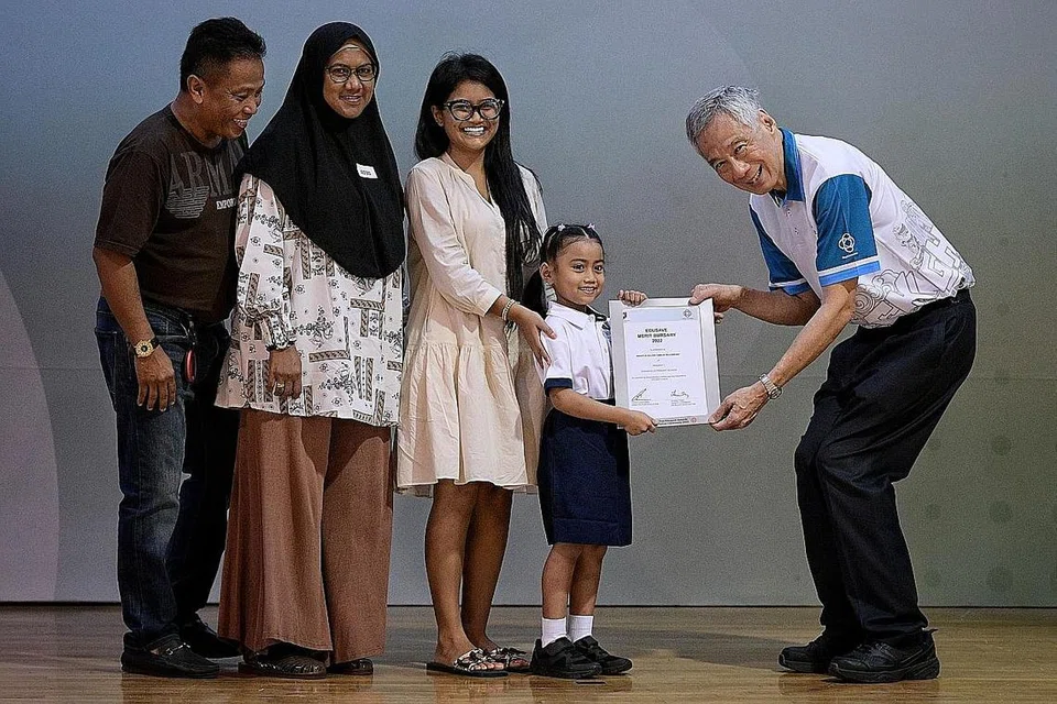 BANTU PENDIDIKAN: Mikayla Aulani, 8 tahun, menerima dermasiswa daripada Encik Lee sambil ditemani ibunya, Cik Baihirah Nurul Baihirah Hanim, 27 tahun, neneknya, Cik Sarimah Mohd, 55 tahun dan datuknya, Encik Abdul Aziz, 58 tahun. - Foto BM oleh NG SOR LUAN