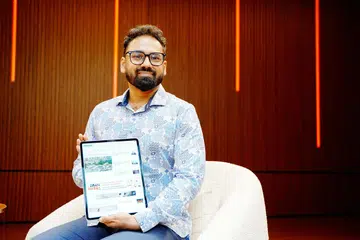 Encik Bhargav Sriganesh, yang sedang memegang peranti tablet dengan aplikasi Berita Harian (BH), turut mengamalkan tabiat membaca akhbar ini untuk membina kosa kata.