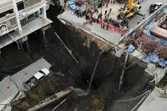 Sebuah kenderaan kelihatan hampir terjatuh di tepi lubang benam besar yang terbuka di Jalan Samsen berhampiran Hospital Vajira, Bangkok, Thailand, 24 September 2025    