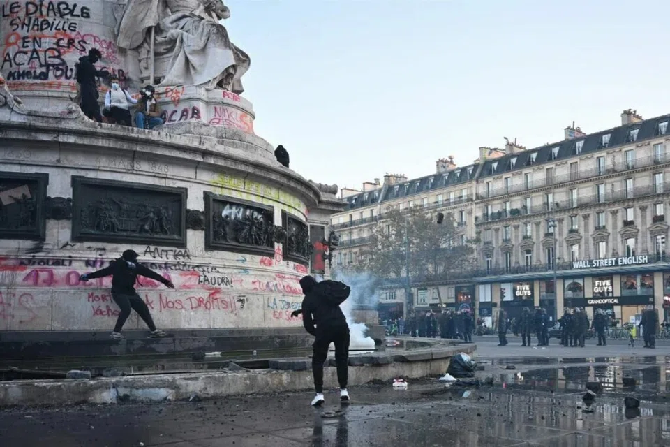 Penunjuk perasaan memecahkan pancuran air di kaki Statue de la République untuk mendapatkan batu ketika pertempuran tercetus di dataran Republique, Paris, pada 18 Oktober.
