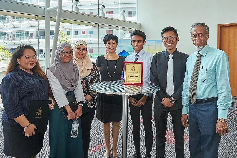 ANUGERAH CEMERLANG: Cik Indranee Rajah (tengah) bersama lima pelajar ITE yang dicalonkan sebagai pelajar cemerlang. Mereka ialah (dari kiri) Cik Batrisyia Shawal, Cik Qurratu' Aini Rashid, Cik Siti Aisyah Sahan, Encik Danial Rashid, Encik Amirul A Latif. Bersama mereka ialah Presiden Persatuan Persuratan Pemuda Pemudi Melayu (4PM), Encik Izzuddin Taherally (paling kanan). - Foto BH oleh ROSLEE RAZAK