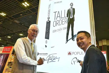 BUKU LARIS: Encik Goh (kiri) dan Encik Peh (kanan) menandatangani papan bercahaya di sesi dialog dan sesi menandatangan buku Tall Order: The Goh Chok Tong Story di Dewan Persidangan Suntec City, semalam. - Foto BM oleh CHONG JUN LIANG