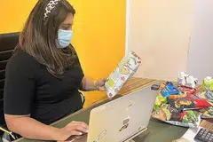 KERJA KERAS: Pengarah Asian Food Network Pte Ltd, Cik Anusha Aswani, sedang memuat naik maklumat terkini tentang kerepek baru syarikat mereka. - Foto-foto ASIAN FOOD NETWORK PTE LTD