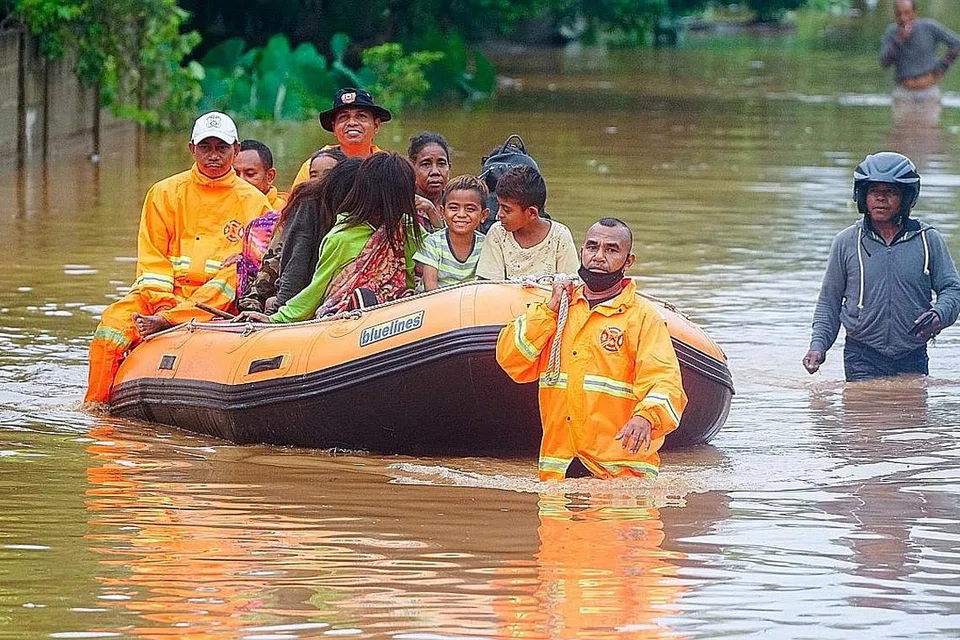 USAHA MENYELAMAT: Pekerja penyelamat membantu mangsa di kawasan yang terjejas banjir akibat hujan lebat di Dili, Timor Leste. - Foto REUTERS